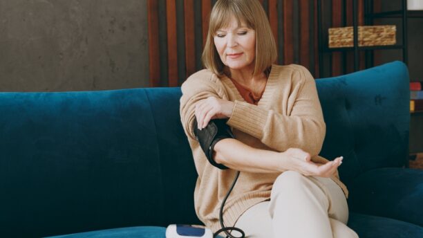 Woman checking high blood pressure with monitor