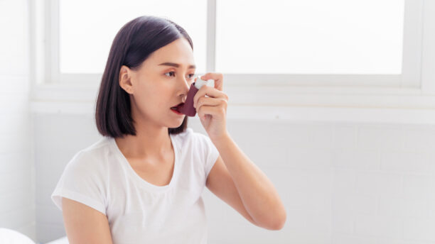 Woman with asthma using inhaler