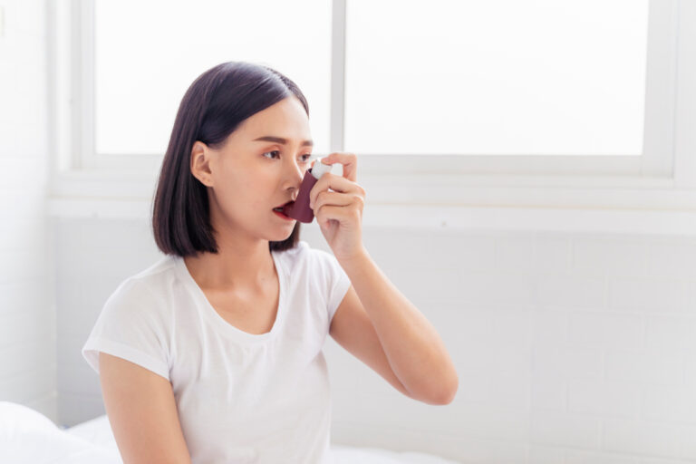 Woman with asthma using inhaler