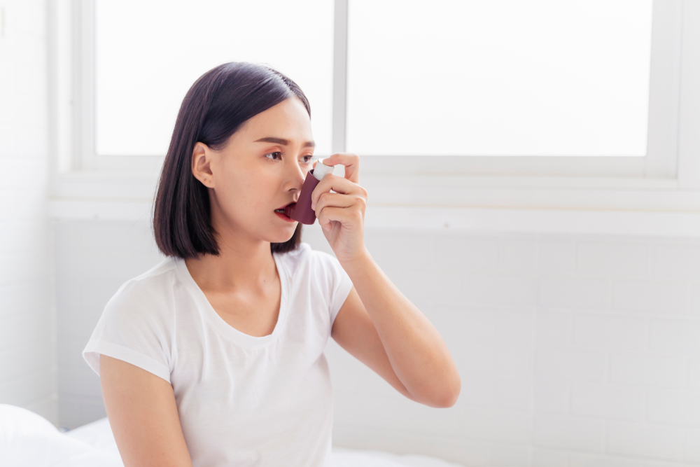 Woman with asthma using inhaler
